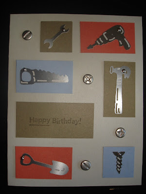 Gray card with squares and rectangles of ornage, blue and green card stock. Embellished with tool-shaped charms and brads that look like screws.