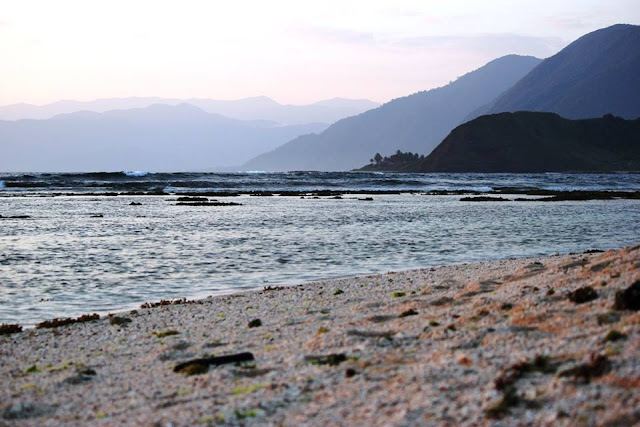 A magnificent view of a distant mountains beyond the sea horizon.
