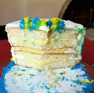 remains of the birthday cake after it was served, revealing the 4 layers of bakery style white cake and creamy vanilla pudding filling