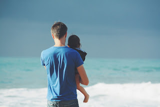 father and daughter looking out at the ocean