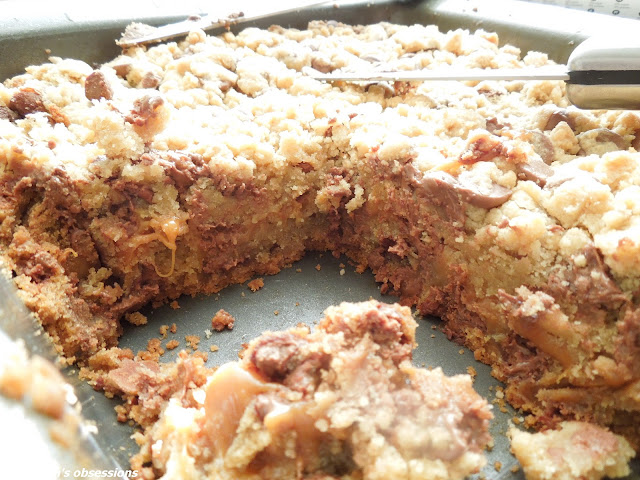 caramel stuffed chocolate chip cookie bars cut in a metal pan with a knife