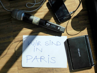 Mikrofon auf dem Boden, daneben ein Schild "Wir sind in Paris"