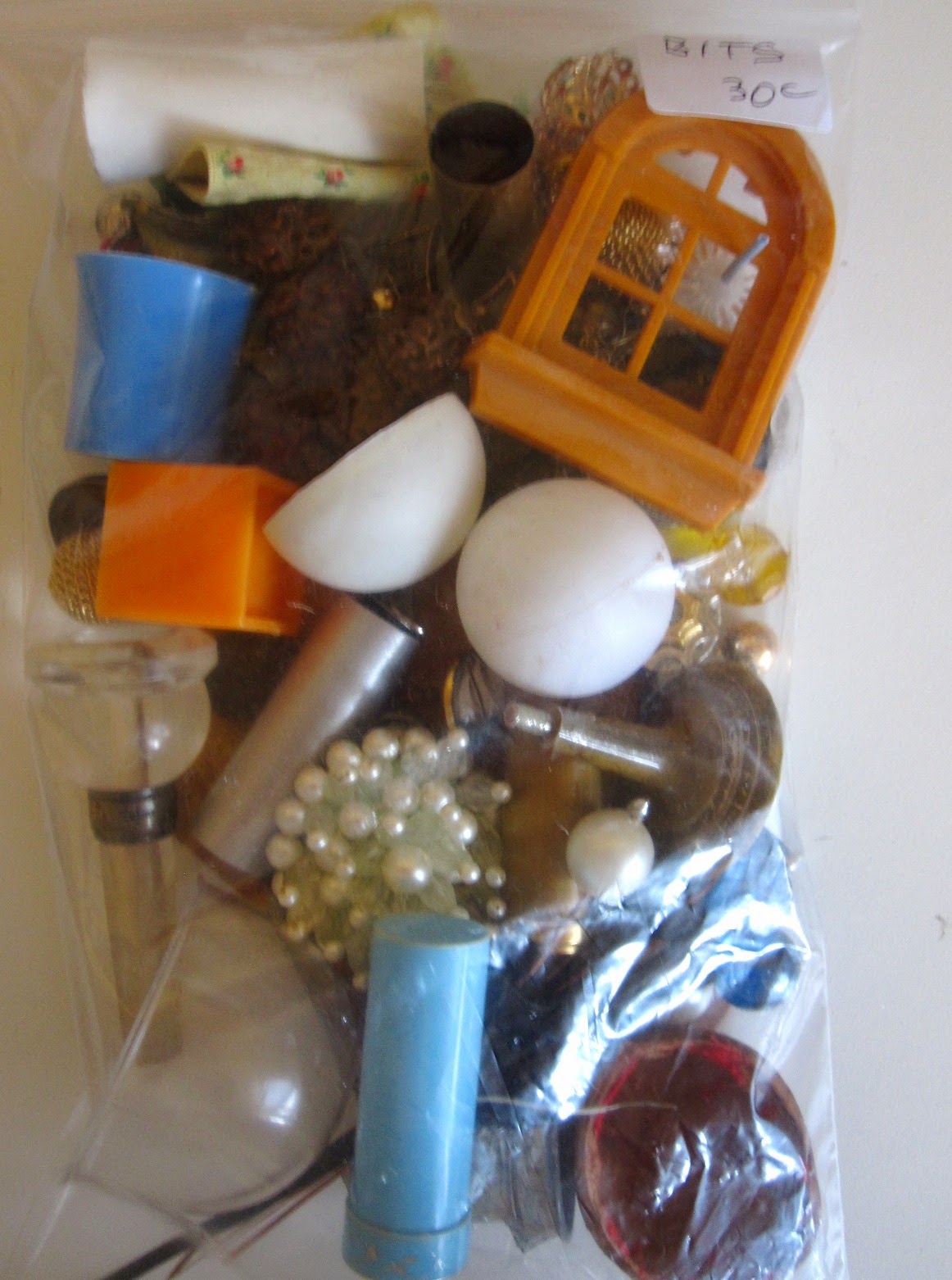 A5-sized bag of bits and bobs for miniature use. Bag is marked 'Bits 30c' and contains a variety of vintage earrings, containers and jewellery pieces.