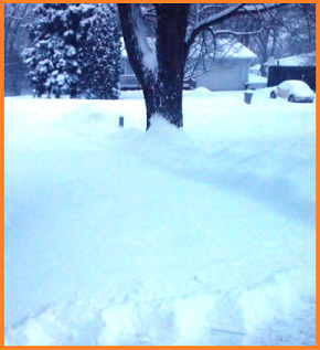 Long, mostly unshoveled driveway.  A slight area at the very bottom of the image shows a very thick cutting of snow.