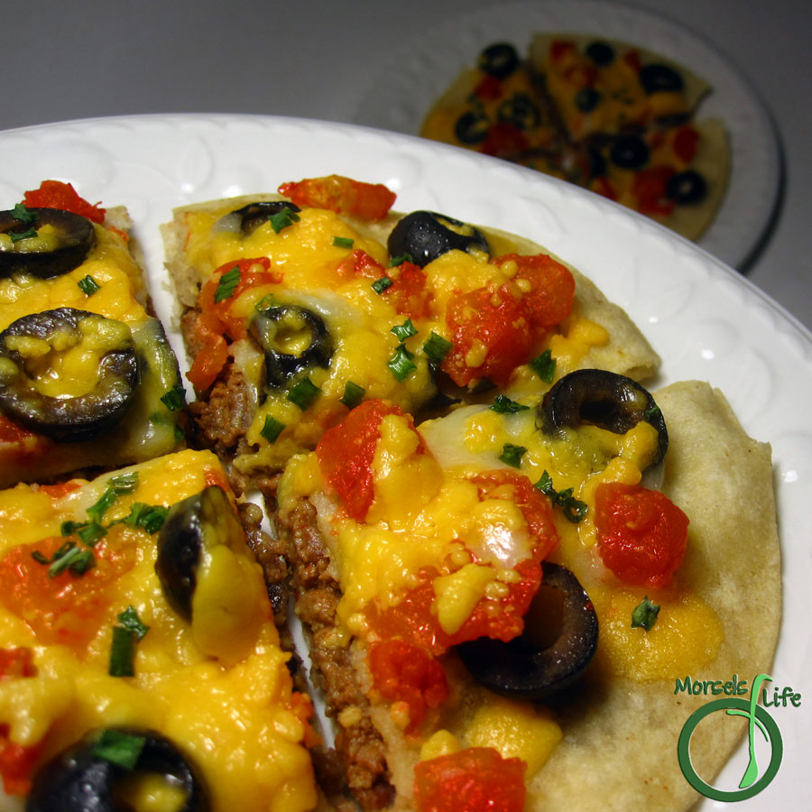 Morsels of Life - Mexican Pizza - An easy Mexican pizza - two crisp corn tortillas filled with ground beef and refried beans, then topped with cheese, tomatoes, olives, green onions, and any other taco toppings you'd like!