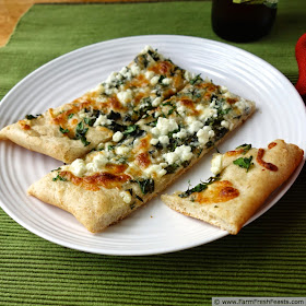 A mix of fresh herbs and a blend of tangy cheeses on roasted garlic oil for a light summer pizza.
