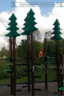 3 year old climbing fake trees at the playground