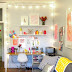 bright & happy workspace. love the strung lights and the artwork taped on the wall.