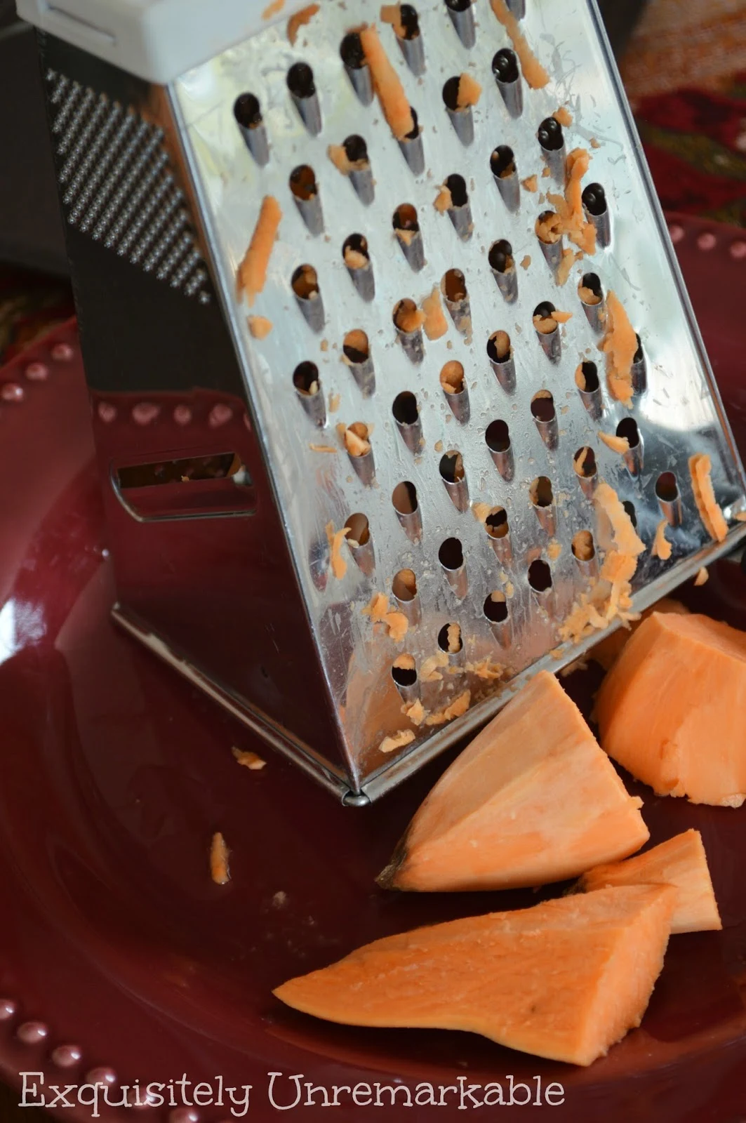 Shredding a sweet potato with a grater