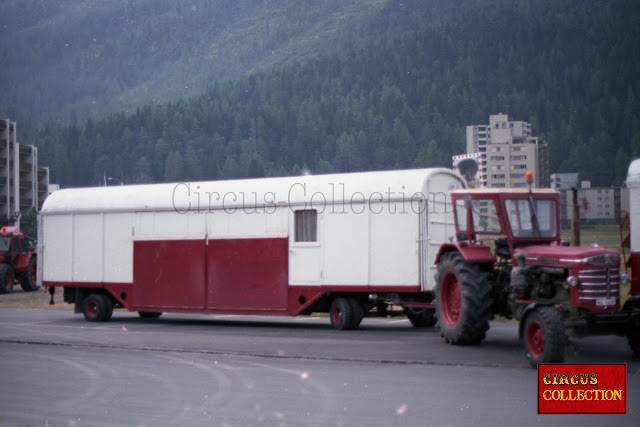 Camion et roulotte façade du cirque Nock arrivant sur la place au bord du lac de Saint-Moritz