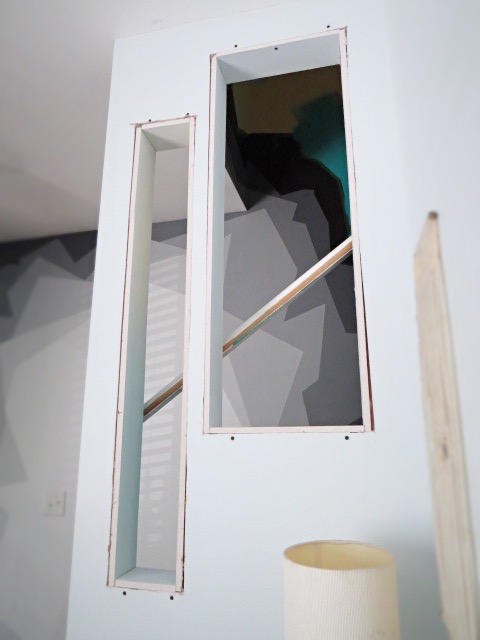 setting drywall pieces into wall cutouts