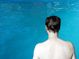 Why Am I Not Improving Image of a man standing looking at the pool: this article is about, Learn How To Swim For Adults - Why I Am Not Getting Better