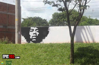 partial jimi hendrix graffiti mural with tree in background