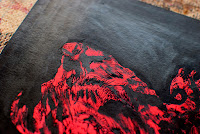 Close up photo of Kostas Gogas' 'Monstrous Red' artwork depicting a red high-contrast abstract shape on a black background. Click to enlarge.