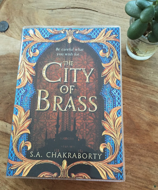 The city of brass book cover brown and blue with plant