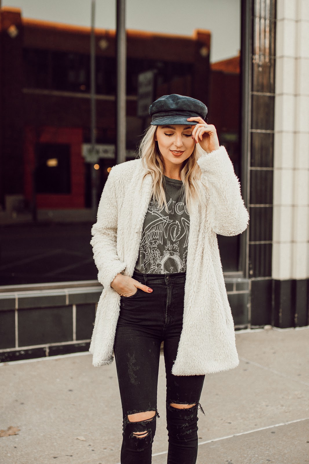 faux fur coat over a graphic tee and ripped jeans