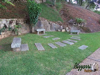 Muro de pedra com pedra rachão tipo de pedra cortada a mão. Muro de pedra rachão com o caminho de pedra folheta e o banco com pedra folheta.