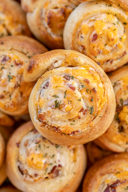 Crack Pinwheels - SO addictive!!! Ranch seasoning, cream cheese, cheddar cheese, and bacon baked in pizza dough - I could eat the whole batch! Great as an appetizer or with soup or stew. Tastes great hot out of the oven or at room temperature. These cheesy bread pinwheels don't last long! #cheddar #bacon #ranch #tailgating #tailgatingrecipes #bread #appetizer Crack Pinwheels - SO addictive!!! Ranch seasoning, cream cheese, cheddar cheese, and bacon baked in pizza dough - I could eat the whole batch! Great as an appetizer or with soup or stew. Tastes great hot out of the oven or at room temperature. These cheesy bread pinwheels don't last long! #cheddar #bacon #ranch #tailgating #tailgatingrecipes #bread #appetizer