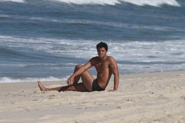 Rodrigo Simas sentado à beira mar