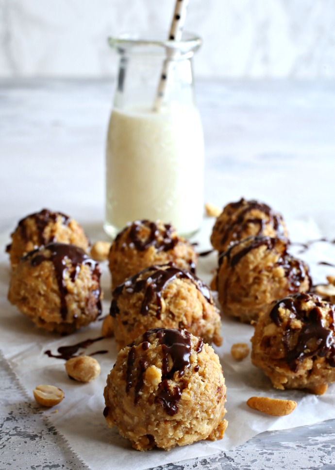 Peanut butter balls filled with pretzels and peanuts, topped with melted chocolate.