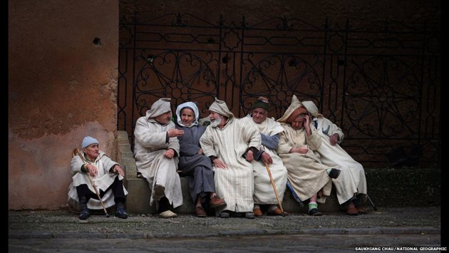 رجال متقدمين في السن يرتدون الجلباب ويتجاذبون أطرف الحديث في شيفشاوين شمال غربي المغرب