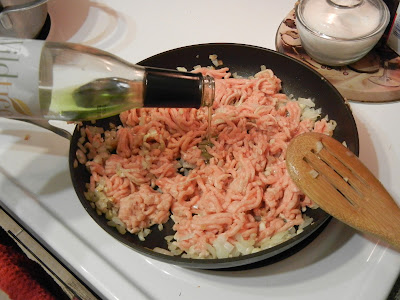 ground Chicken in a pan with a wooden spoon to the right 
