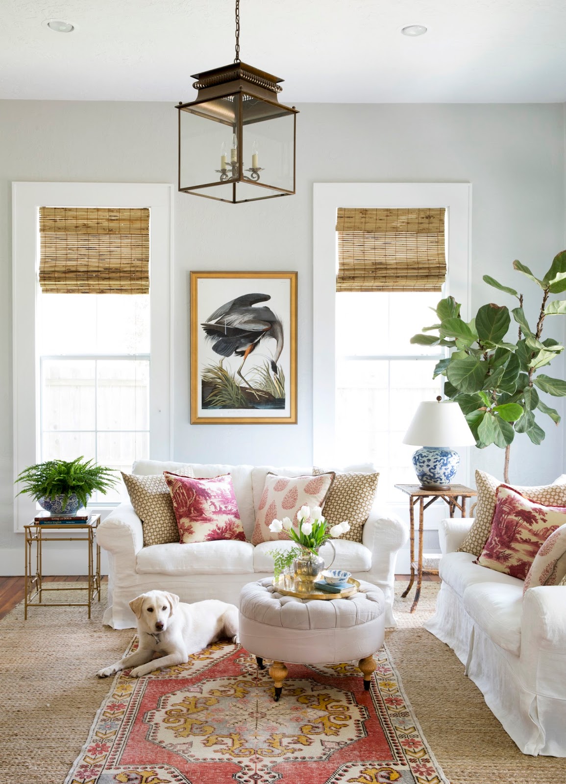 Charming cottage style living room with faded red accents, vintage decor, and interior design by Holly Mathis. #livingroom #cottage #vintagestyle #traditional