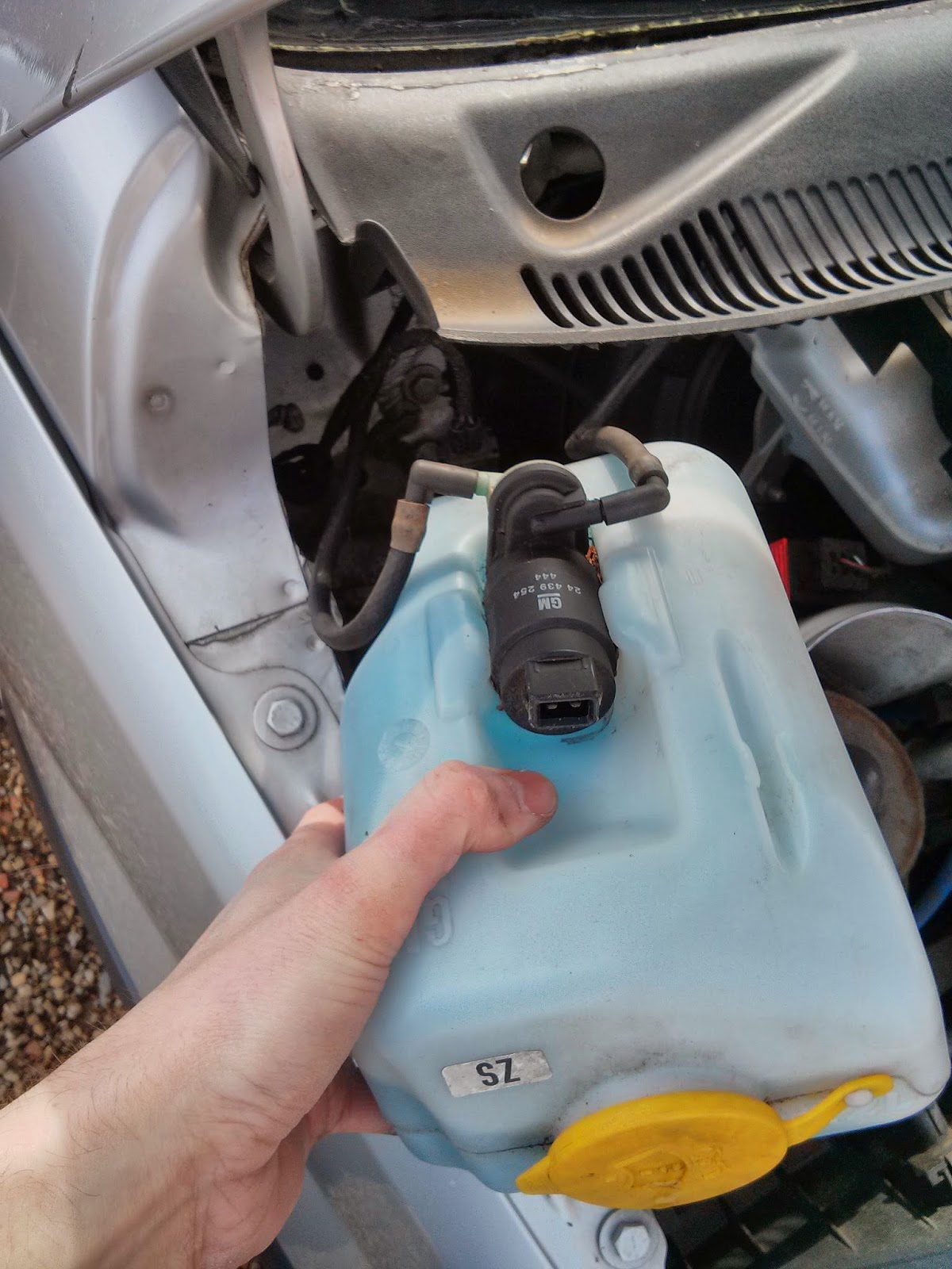 Remove washer bottle by pulling it straight up. Hoses disconnect by simply pulling but but make a note for re-installation which nozzle is for front and ...