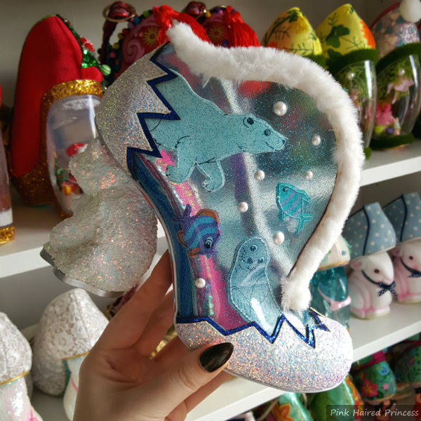 Irregular Choice Family Reunion Fuzzy McFrosty polar bear heeled shoe in hand in front of shoe shelves