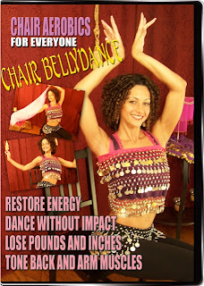 The cover of the Chair Aerobics for Everyone: Chair Bellydance dvd.  Has a long, curly haired woman sitting down on the cover with a coin scarf tied over her sports bra, coin scarf on hips, black pants, arms overhead. Text reads "restore energy, dance without impact, lose pounds and inches, tone back and arm muscles"