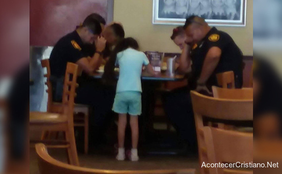 Niña orando por policías en un restaurante