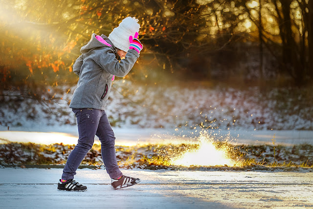 image of a girl playing in the snow captured with a Fuji X system camera and the Fujinon 50-140mm by Willie Kers