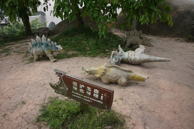 several small models of dinosaurs that are in various states of decay or knocked over