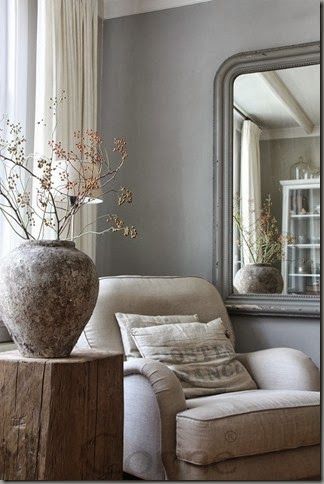 A gorgeous European country moment in a living room with cozy armchair and oversized stone vase. #belgianstyle #frenchcountry #greywalls