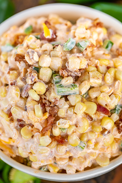Jalapeno Popper Corn Salad - crazy delicious creamy corn salad. I made this for a cookout and it was gone in a flash! I should have doubled the recipe!! Corn, jalapenos, bacon, mayonnaise, cream cheese, sour cream, onion, garlic, chili powder, paprika, pepper jack cheese, and cheddar cheese. Can make in advance and refrigerate overnight. A real crowd pleaser! #corn #salad #sidedish #cornsalad corn salad in a bowl