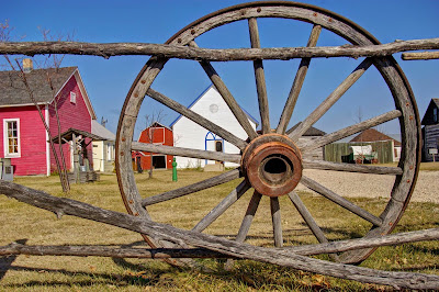 Pioneer village as seen through a wagon wheel