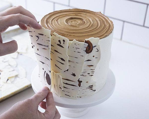 Place the strips of bark on the sides of the cake Place the strips of bark on the sides of the cake