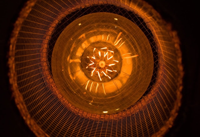 An orange utility light, looking up from the bottom into it's casing