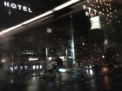 Blick aus dem Autofenster auf ein Hotel, Regen auf der Glasscheibe Blick aus dem Autofenster auf ein Hotel, Regen auf der Glasscheibe