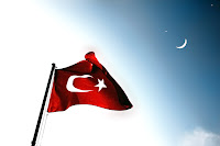 Bir bayrak direğinde dalgalanan Türk Bayrağı ve gökyüzündeki ay yıldız
