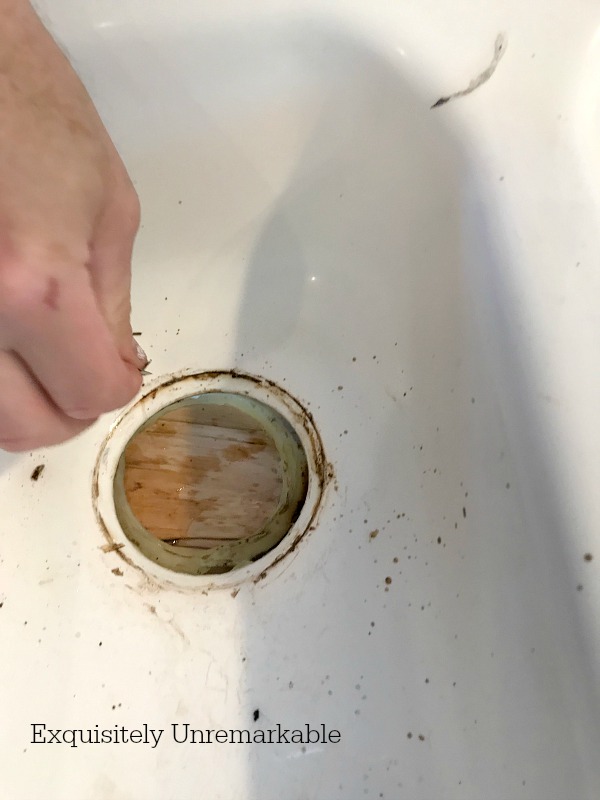 Cleaning the drain in a white sink