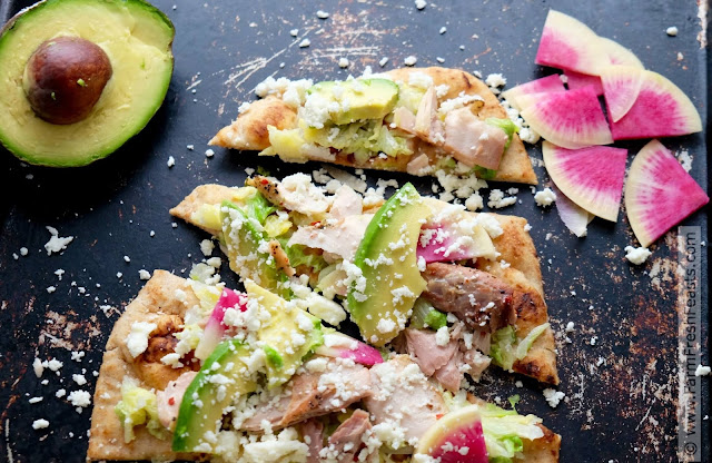 A fast and easy fresh tasting pizza this simple naan crust is topped with mahi mahi, sautéed Napa cabbage, avocados, watermelon radishes, and crumbled queso.