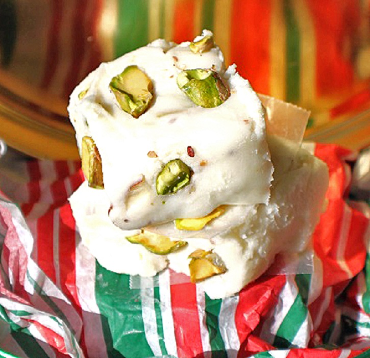 this is an easy how to make white chocolate amaretto fudge with pistachios in it in a green white and red paper Christmas tins for gift giving