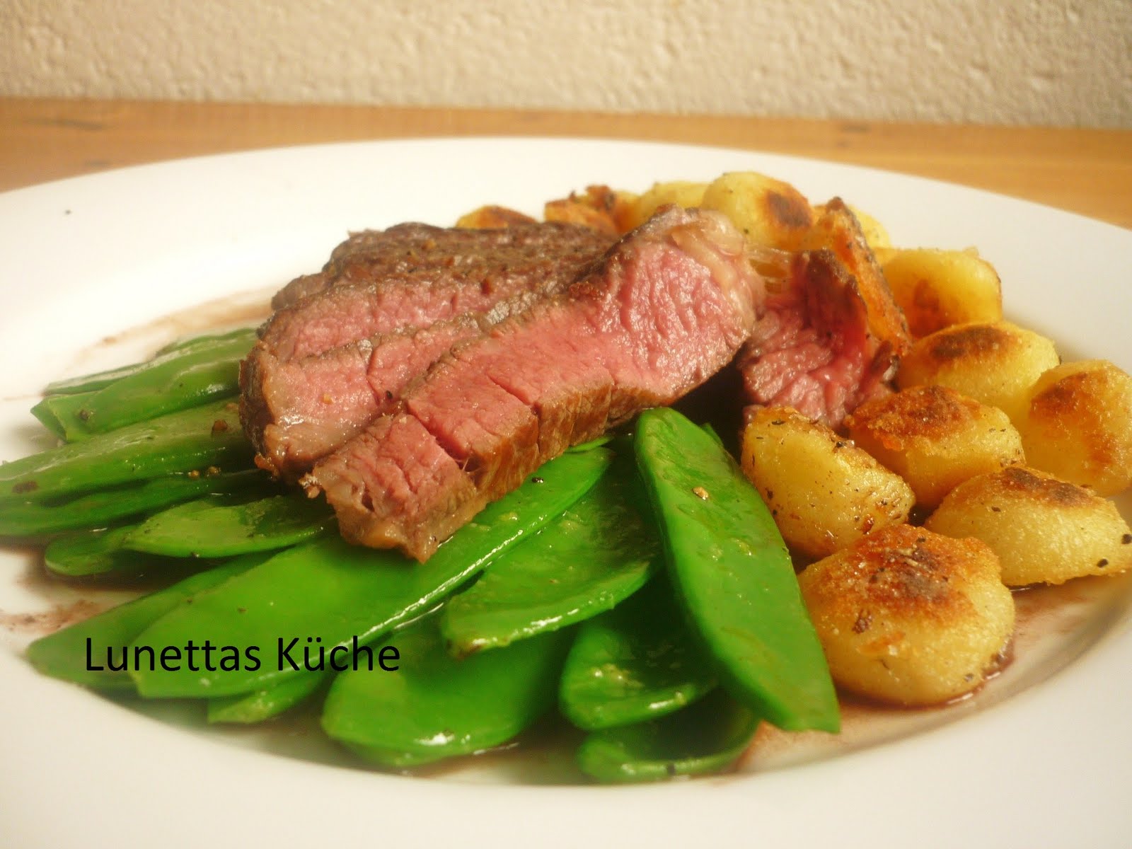 Hohrückensteak mit Rotweinjus, Bratkartoffeln und Kaiserschoten