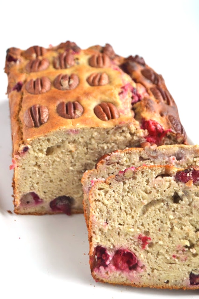 This Cranberry Pecan Banana Bread is lightened up with Greek yogurt, less sugar and whole-wheat flour! Topped with crunchy pecans and loaded with tart cranberries! www.nutritionistreviews.com