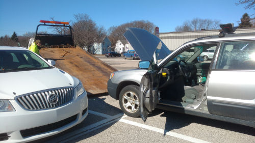 car being loaded onto a flatbed tow truck
