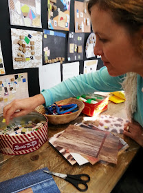 A woman selecting paper for her collage in the children's room at The Daylight Moon exhibition.