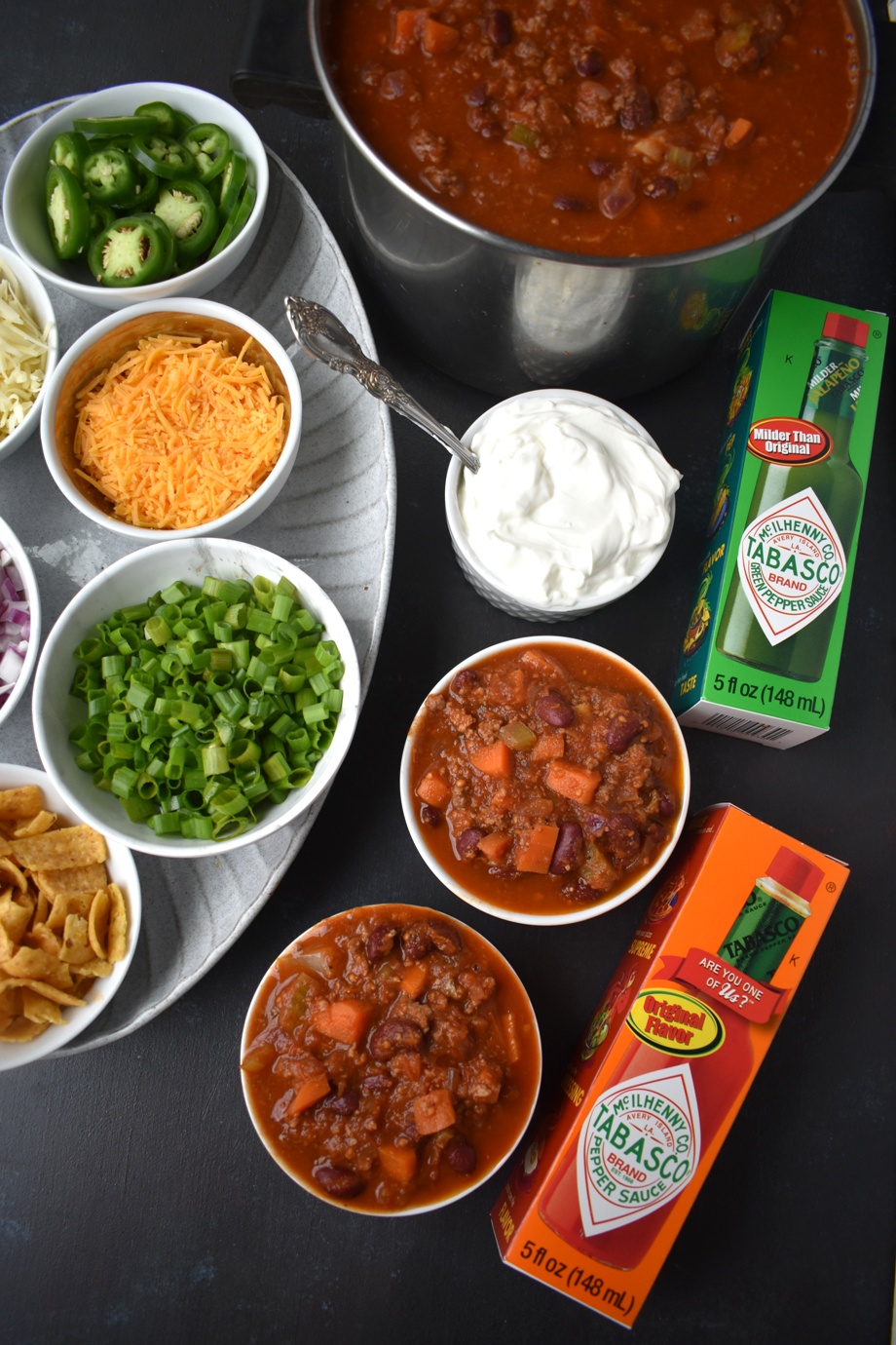 The Ultimate Chili Bar features a spicy turkey chili and all the toppings including shredded cheese, red onions, jalapenos, hot sauce, corn chips, sour cream and green onions. Perfect for entertaining and easy to make in large quantities. www.nutritionistreviews.com #chili #soup #healthy #turkey #spicy Make your own chili bar