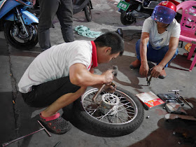 man fixing a motorcycle wheel