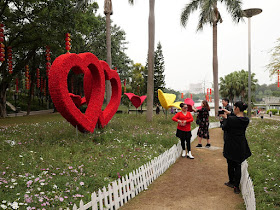 woman posing for photo in front of heart-shaped flower sculptures